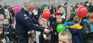 Policjant w towarzystwie najmłodszych uczestników targów pracy