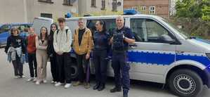 wspólne zdjęcie opiekuna grupy z policjantami i młodzieżą