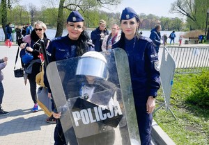 Policjantki z chłopcem ubranym w strój policyjny ubierany podczas zabezpieczeń imprez