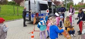 dzieci w towarzystwie policjantów w tle radiowóz