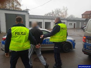 Policjanci prowadzą podejrzanego o rozbój 30-latka