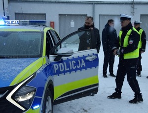 Przekazanie radiowozu. Na zdjęciu radiowóz obok stojący  przedstawiciele samorządu oraz policjanci