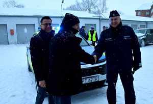 Przekazanie radiowozu. Na zdjęciu radiowóz obok stojący  przedstawiciele samorządu oraz policjanci