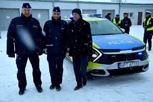 Przekazanie radiowozu. Na zdjęciu radiowóz obok stojący  przedstawiciele samorządu oraz policjanci