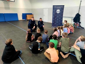 Policjanci prowadzący prelekcję z dziećmi przebywającymi na półzimowisku