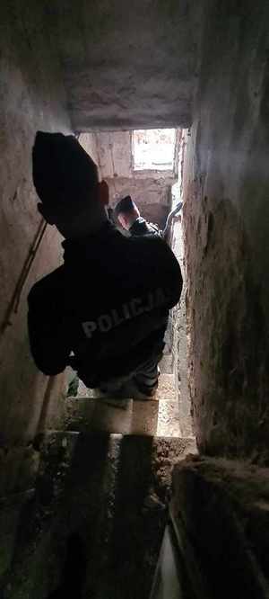 Policjant kontroluje miejsce przebywania osób bezdomnych