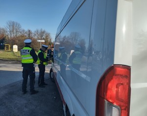 Policjanci kontrolują białego busa