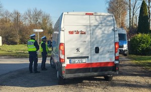 Policjanci kontrolują białego busa