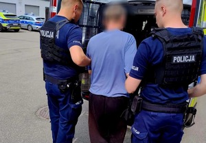 zatrzymany mężczyzna osadzany w radiowozie