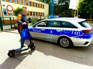 kontrola kierującego hulajnogę, kierowca jednośladu na tle radiowozu
