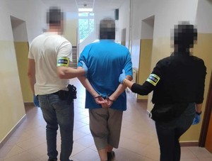 Zatrzymany 61-latek prowadzony przez nieumundurowanych policjantów