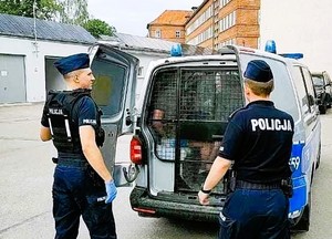Policjanci stojący przy radiowozie