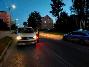 Badanie stany trzeźwości kierującego białym busem wykonywane przez policjanta